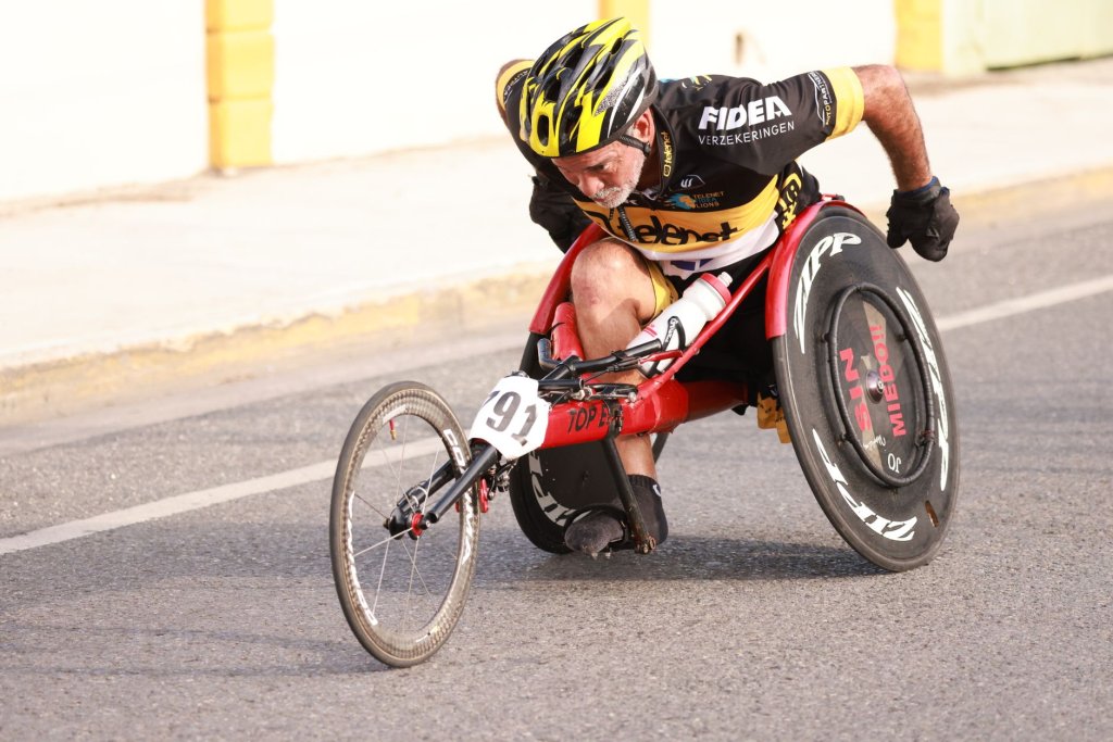 l-equipe-paralympique-vietnamienne-installee-au-japon-2 Athlète en fauteuil roulant de course, casqué, propulsant son tricycle sur une route