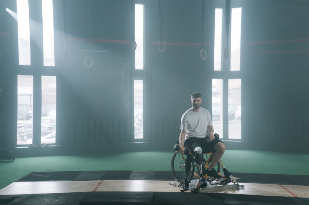 le-van-cong-decroche-l-argent-aux-jeux-paralympiques-asiatiques-2026 Un homme en fauteuil roulant avec une prothèse de jambe dans une salle de sport, sous des faisceaux de lumière