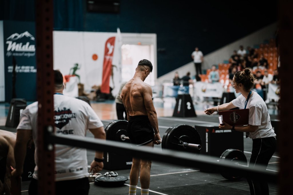 le-van-cong-decroche-l-argent-aux-jeux-paralympiques-asiatiques-2026-2 Haltérophile torse nu devant une barre chargée, encadré par des juges lors d’une compétition